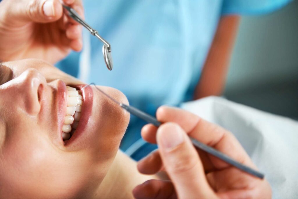 patient smiling and receiving a regular dental checkup