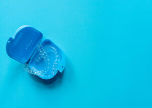 a set of clear aligners laying in a blue case