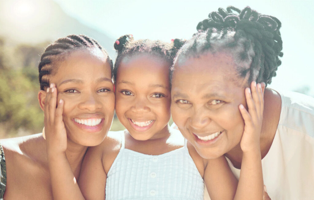 This outdoor portrait features three individuals showcasing distinct braided hairstyles. On the left, cornrow braids are neatly aligned against the scalp; in the center, two braided pigtails are secured with small hair ties; and on the right, thick, twisted braids cascade down.